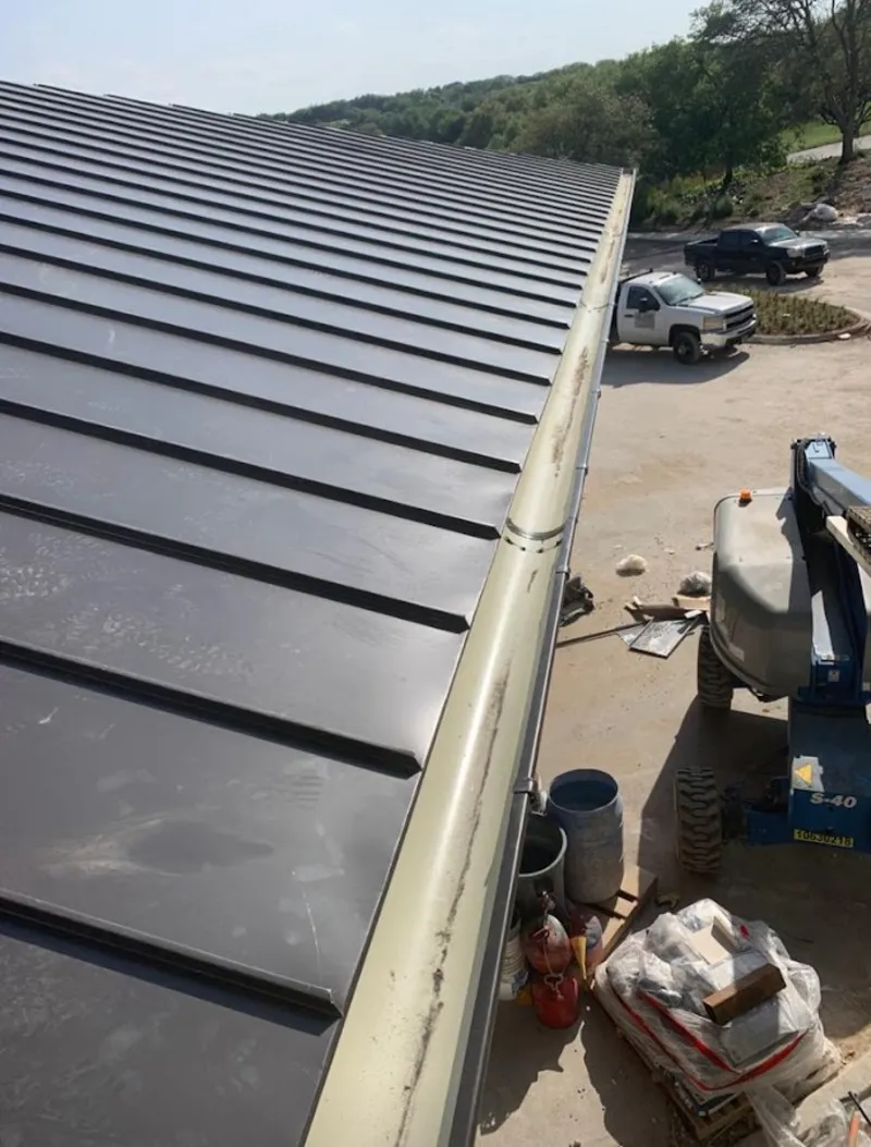 Standing seam panel and gutter detail on a metal roofing jobsite in Ross